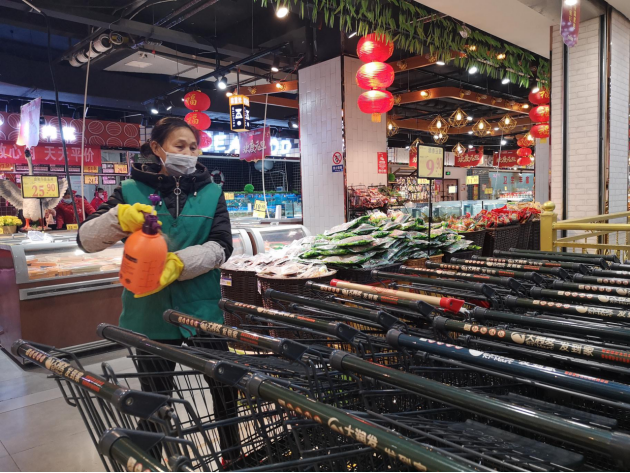 超市保洁员正在对购物车进行消毒