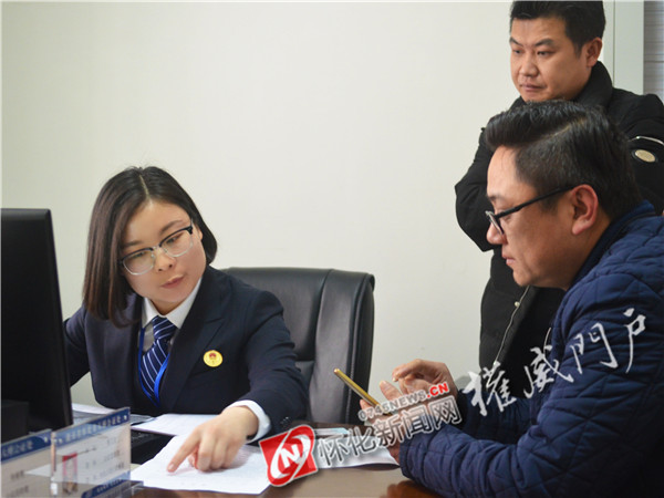 (承办公证人员正指导市民填写公证申请表格)